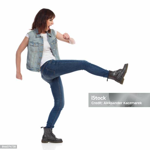 Angry Young Woman Is Shouting And Kicking Side View Stock Photo - Download Image Now