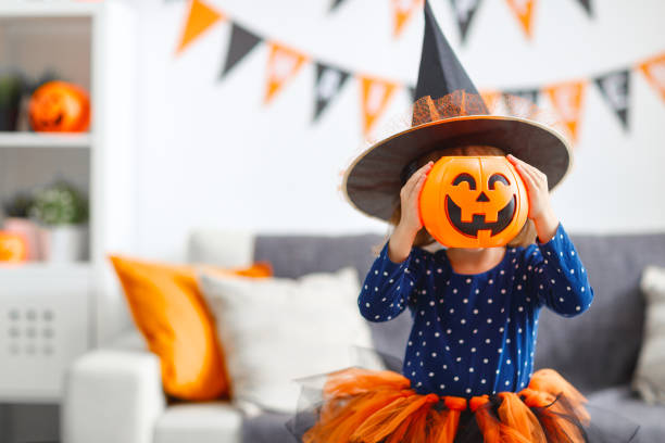 felice bambina ragazza in costume strega ad halloween - halloween pumpkin party carving foto e immagini stock