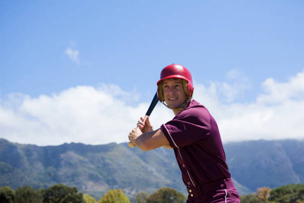 istock Smiling baseball player with bat against mountains 846086098