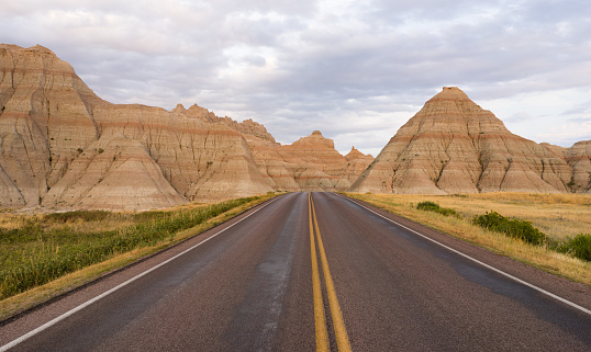 The road leads through rock formations in the South Dakota Badlands