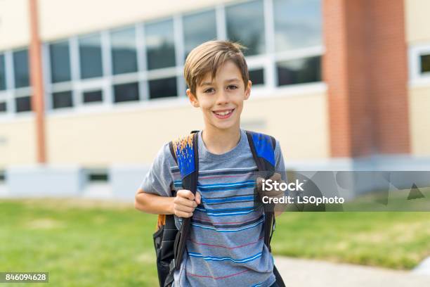 Great Portrait Of School Pupil Outside Classroom Carrying Bags Stock Photo - Download Image Now