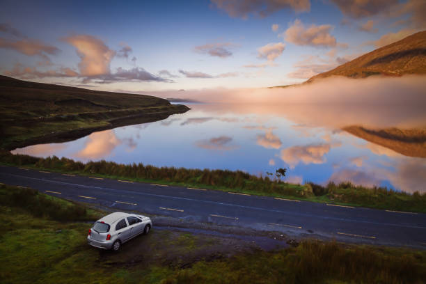 Connemara road early in the morning. Travel Destinations in Ireland Car on the Connemara tourist route connemara national park stock pictures, royalty-free photos & images