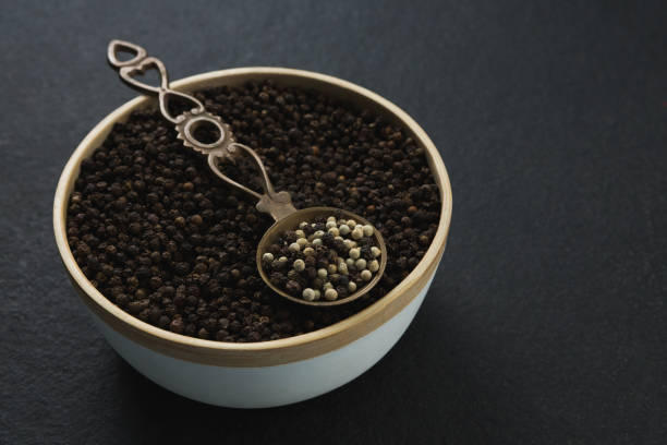 istock Black pepper and white pepper seeds in a bowl 846099930