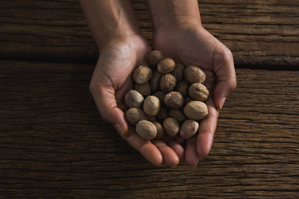 istock Hands holding nutmeg against wooden table 846100158