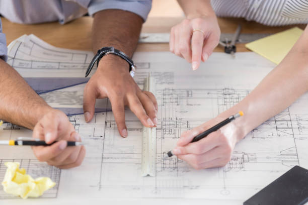 istock Unrecognizable male and female architect work on blueprint 846100222