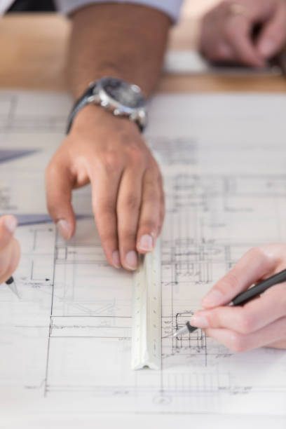 istock Close up of architects' hands working on blueprint 846100228