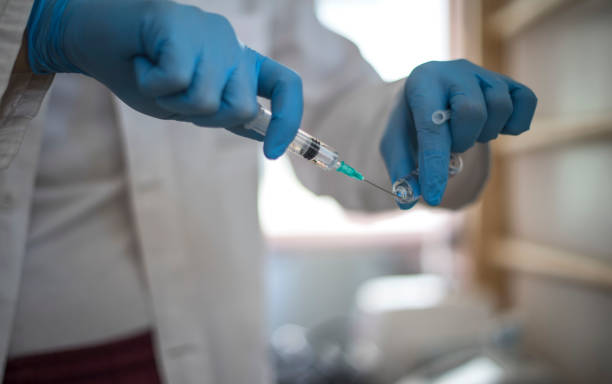 Doctor prepare a syringe for vaccination Doctor prepare a syringe for vaccinate a young girl malaria blood sample stock pictures, royalty-free photos & images