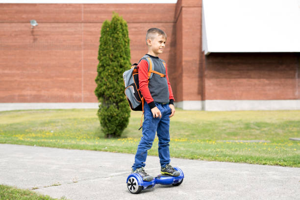 Little boy riding a mini segway. He's good at it. He likes it