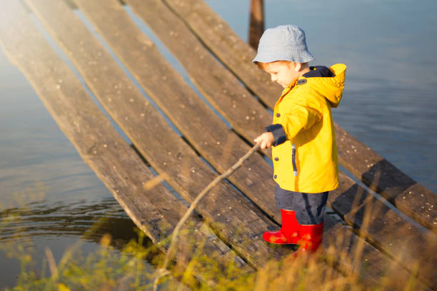 niño pequeño la pesca desde el muelle de madera - sweden fishing child little boys fotografías e imágenes de stock