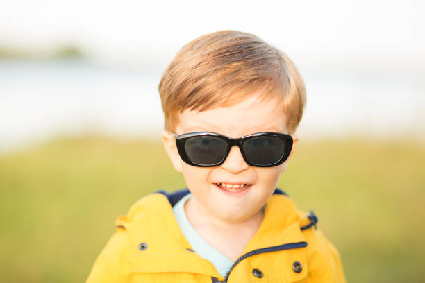 sonrisas de niño lindo jardín en gafas de sol al aire libre - sweden fishing child little boys fotografías e imágenes de stock