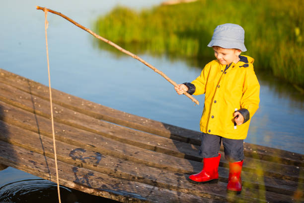 little boy capture d’un poisson du quai en bois - sweden fishing child little boys photos et images de collection