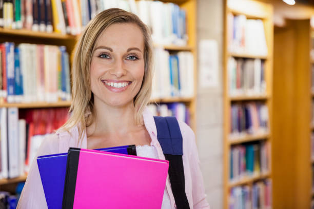 istock Female student holding textbooks in the library 846124068
