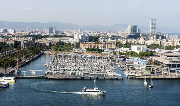 Big Mediterranean skies over the crowded marina of luxury yachts and motor boats beside the fashionable Barceloneta waterfront of Port Vell, Barcelona, Spain.
