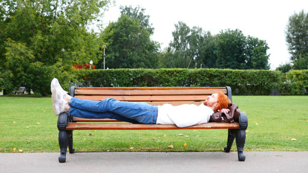 Sleeping Tired Man with Red Beard and Hairs in Park on Bench