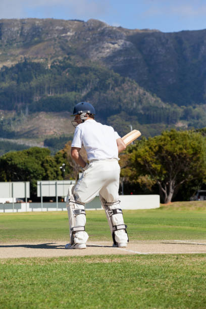 istock Rear view of batsman playing cricket at field 846145268