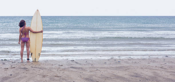 istock Calm woman in bikini with surfboard on beach 846157594
