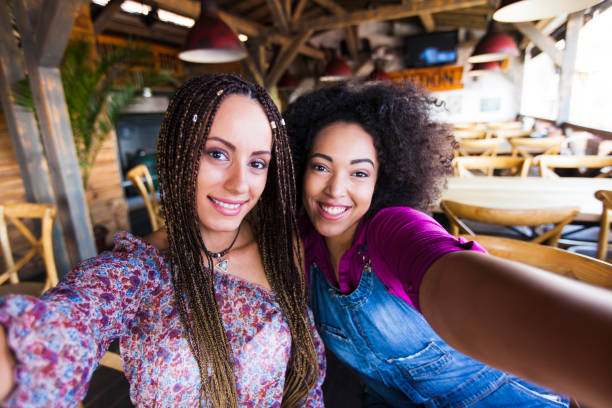istock Cheerful girlfriends taking selfie in cafeteria 846158440
