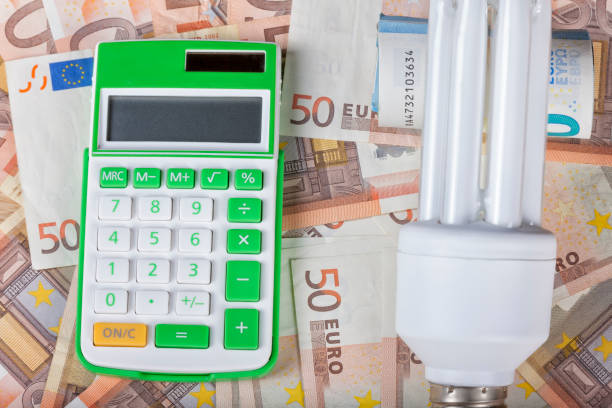 istock Energy saving bulb with calculator and euro banknotes. 846161576