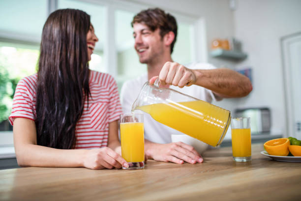 istock Handsome man pouring orange juice in a glass 846164284