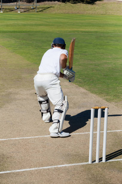 vue arrière du joueur de cricket pratiquer sur terrain - shadow focus on shadow people men photos et images de collection