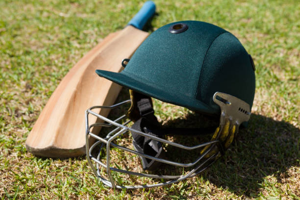 istock High angle view of cricket helmet and bat on field 846167824