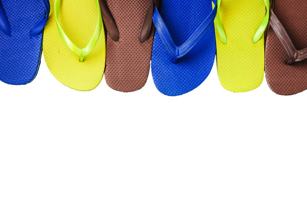 Several pairs of multi-colored rubber flip-flops exhibited in a row, isolated.