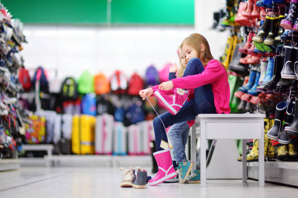 istock Two little sisters choosing and trying on new rain boots 846174660