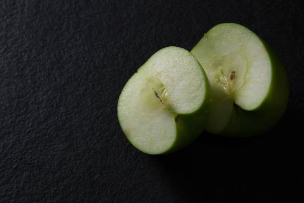 istock Halved green apple on black background 846185840