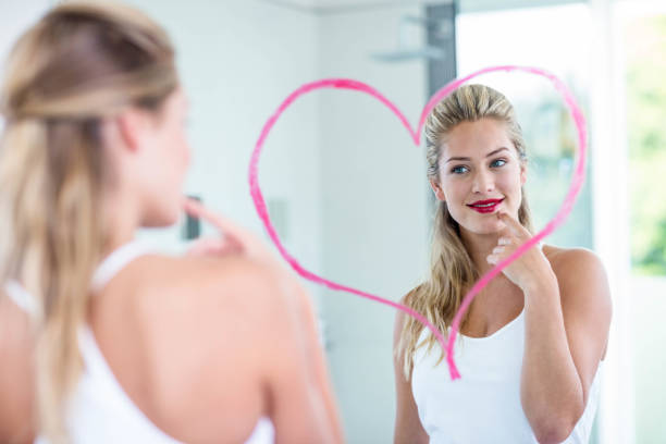 istock Woman with lipstick looking in the mirror 846189158
