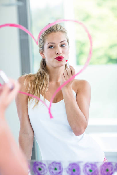 istock Woman with lipstick looking in the mirror 846189176