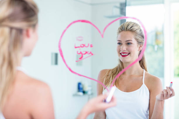 Woman writing on the mirror with lipstick Woman writing on the mirror with lipstick in the bathroom mirror writing stock pictures, royalty-free photos & images
