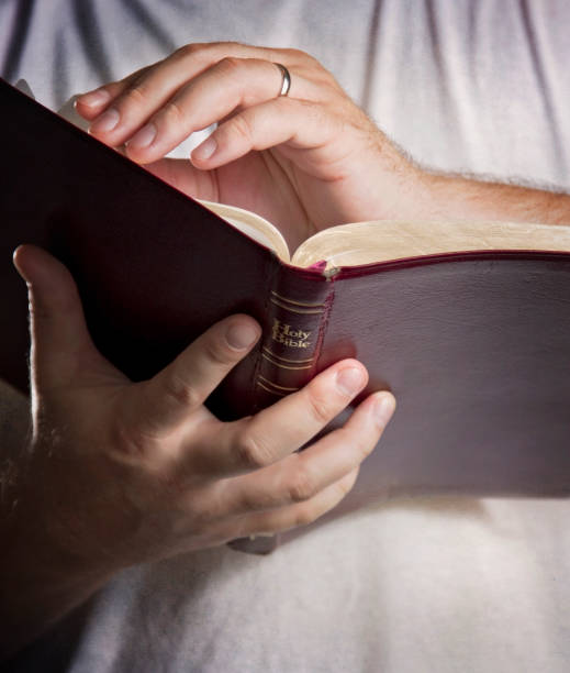 istock Man in a White T-Shirt Reading the Bible 846189438