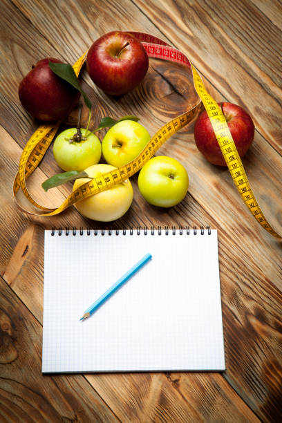 istock Apples, a diet plan and a centimeter on a wooden background 846193464