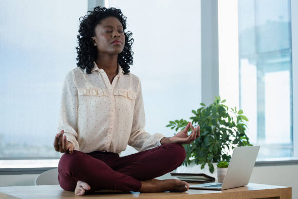 istock Female executive meditating on desk 846196230