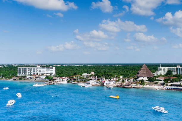 Colorful waters, rocky shore and the traditional restaurant on Cozumel island beach (Mexico).