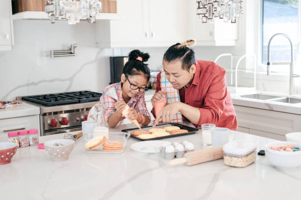 istock Dad and daughter baking cookies together 846204970