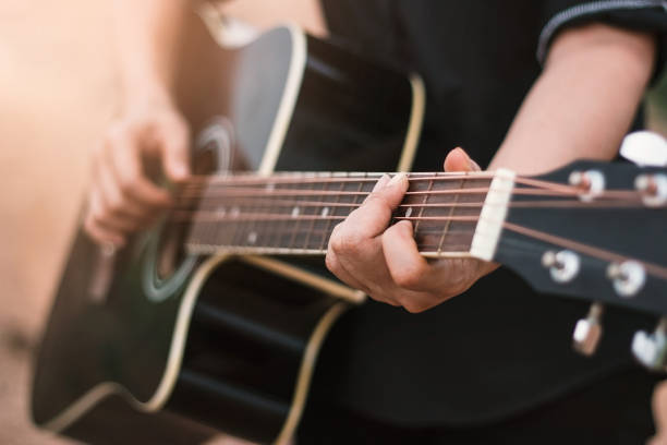 gitarrist spielt akustische gitarre, nahaufnahme - musical instrument people music young adult stock-fotos und bilder