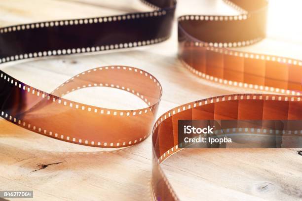 Movie Film Strips On Wooden Background Stock Photo - Download Image Now - Movie, Film Industry, Camera Film