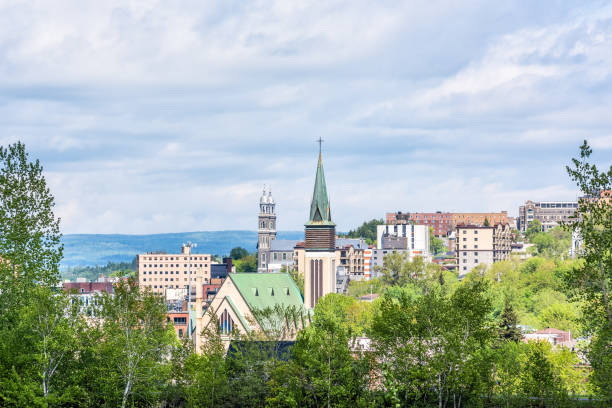 stadtbild oder skyline der stadt saguenay, kanadas in quebec im sommer mit kirchturm, viele häuser, gebäude und bäume grünen park - chicoutimi travel locations nature city stock-fotos und bilder