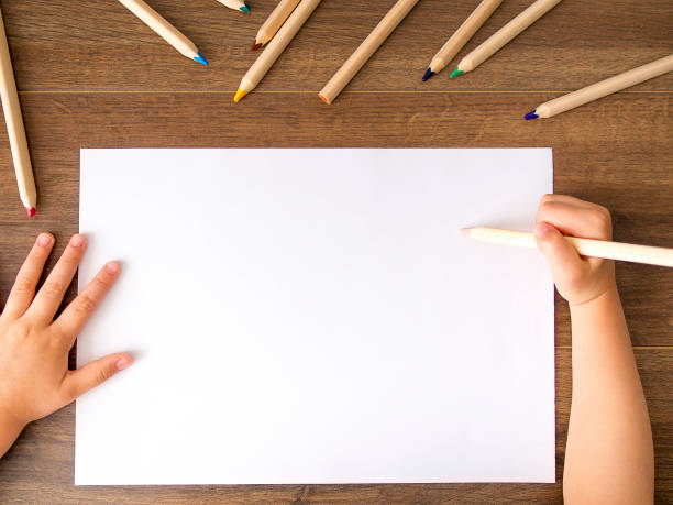 istock Kid holding pencil over empty sheet of paper 846232768