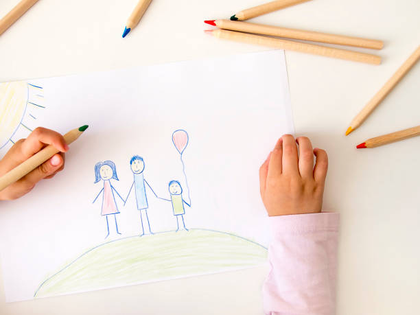 istock Kid drawing a happy family on white table 846232810