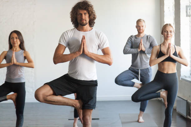 istock Group of young sporty people in Vrksasana pose, studio 846236510