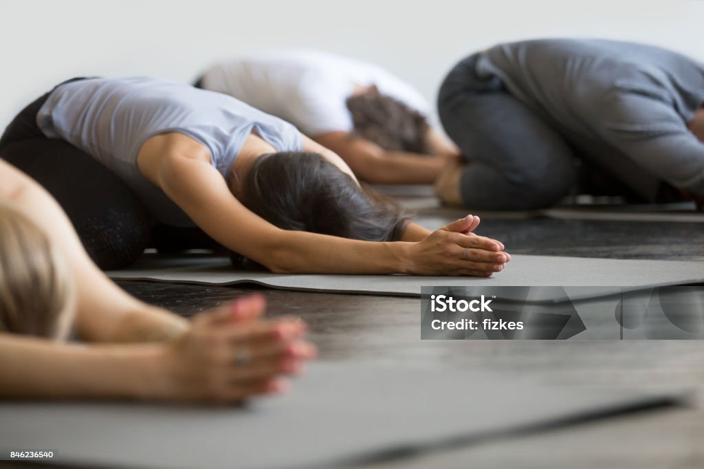 Groupe de jeunes sportifs dans la pose de l’enfant - Photo de Yoga libre de droits