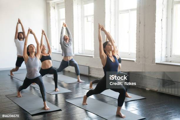 Photo libre de droit de Groupe De Jeunes Sportifs En Guerrier Une Pose Studio banque d'images et plus d'images libres de droit de Yoga