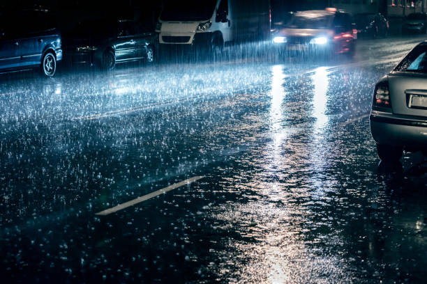 istock car with switched on headlights driving during heavy rain 846236750