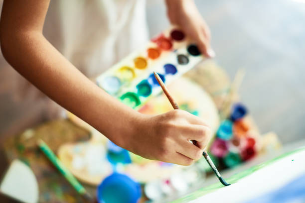 Drawing on Canvas Close-up shot of highly gifted little artist drawing with watercolors on canvas, blurred background paintbrush photos stock pictures, royalty-free photos & images