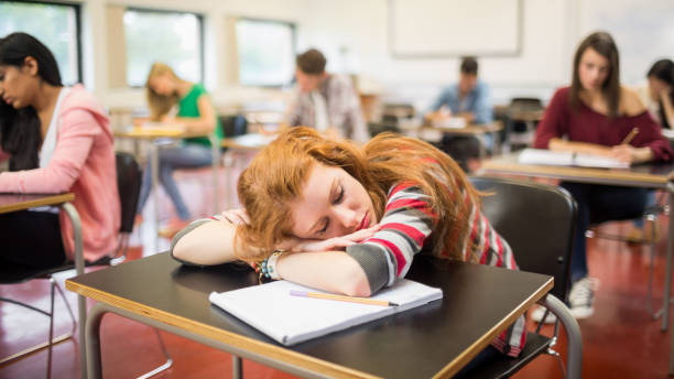 rozmyte uczniów w klasie z jedną śpiącą dziewczyną - student sleeping boredom college student zdjęcia i obrazy z banku zdjęć