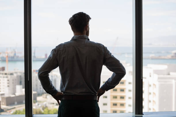 istock Thoughtful male executive looking through window in office 846240894