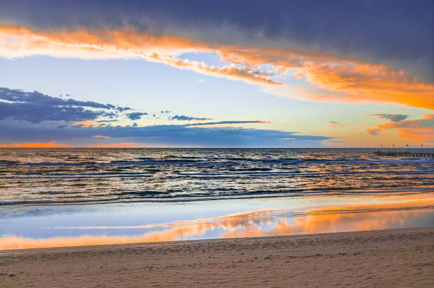 istock Beautiful sunset reflecting in low tide puddles at empty ocean beach 846244064