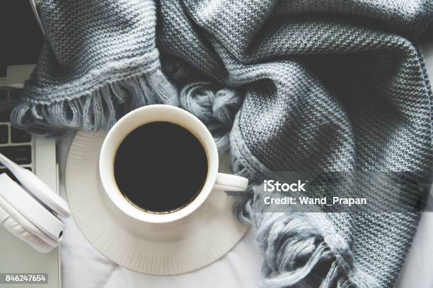 The Laptop Working And Listen Music On The White Bed And Coffee With Marshmallow Warm Knitted Sweater In The Sunny Day Cozy Winter Home Morning Holiday Music And Lifestyle Concept Stock Photo - Download Image Now